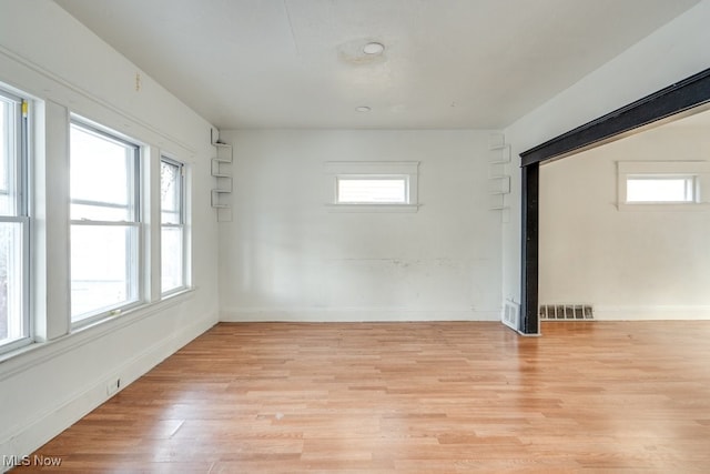 spare room with a wealth of natural light and light wood-type flooring