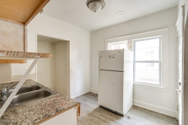 kitchen featuring sink, white fridge, and light wood-type flooring