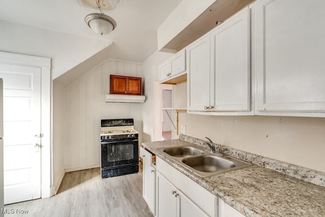 kitchen featuring sink, white range with gas stovetop, white cabinetry, light stone counters, and light wood-type flooring