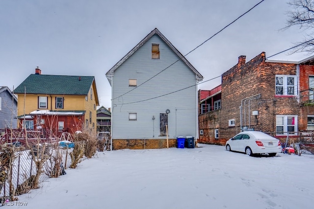 view of snow covered back of property