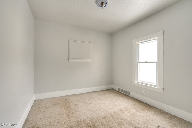 unfurnished room with a textured ceiling and carpet