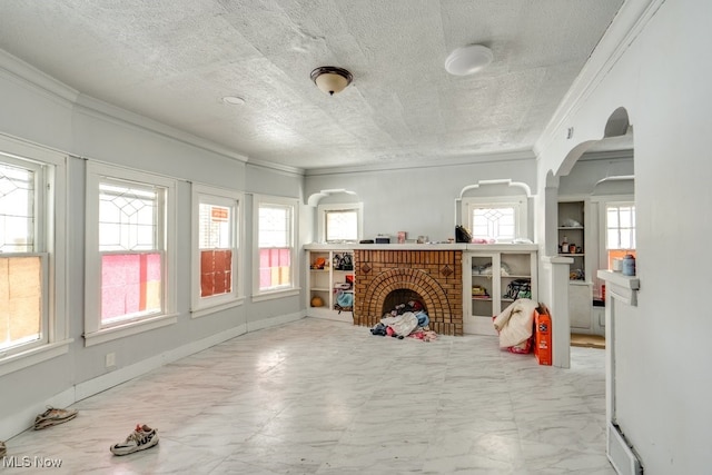 living room with a brick fireplace, crown molding, and a textured ceiling