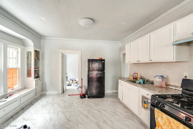 kitchen featuring sink, light stone counters, ornamental molding, black appliances, and white cabinets