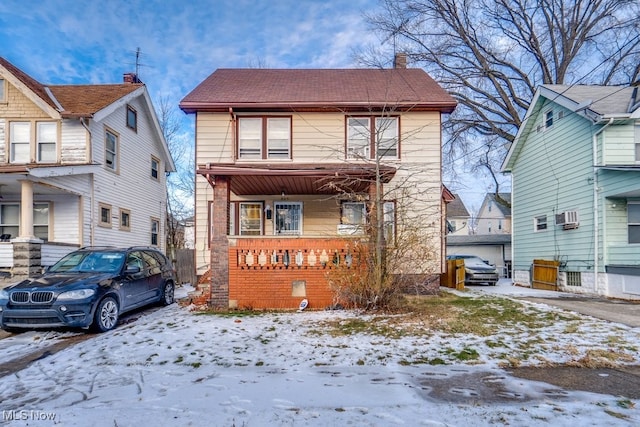 view of front of home with a wall mounted air conditioner and covered porch