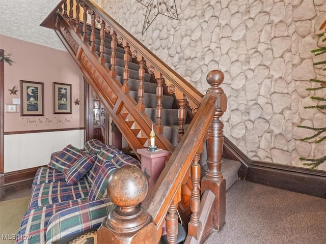 staircase featuring a textured ceiling