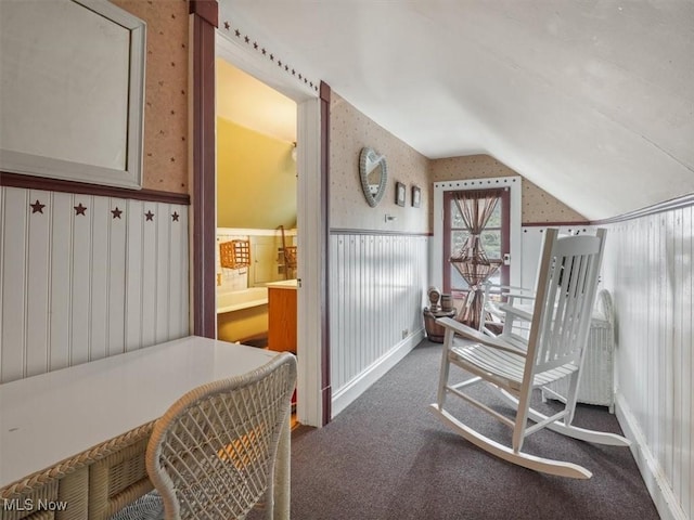 carpeted bedroom featuring vaulted ceiling and ensuite bath