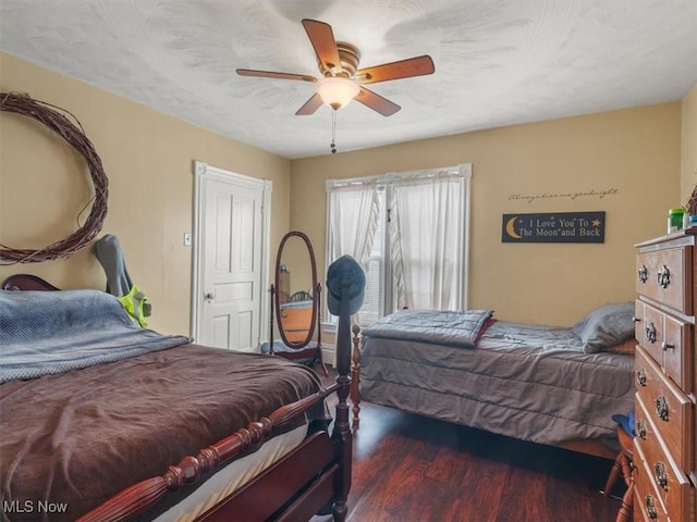 bedroom with dark hardwood / wood-style flooring and ceiling fan