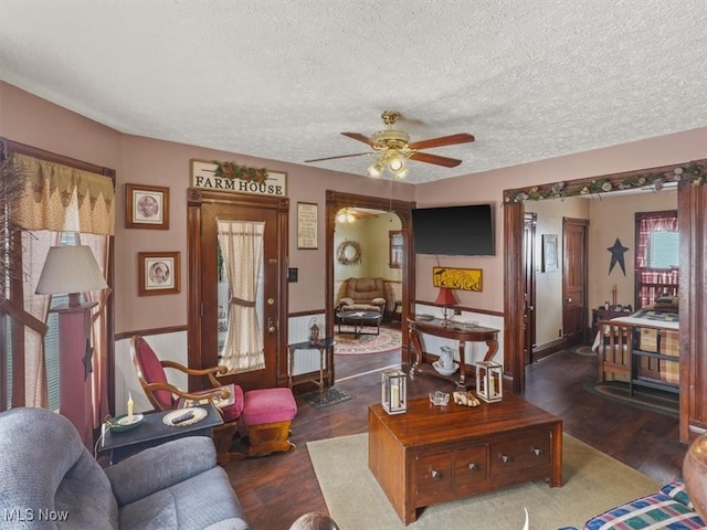 living room featuring ceiling fan, radiator heating unit, dark hardwood / wood-style floors, and a textured ceiling