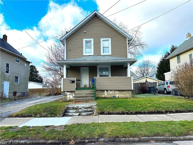 view of property featuring a porch and a front lawn