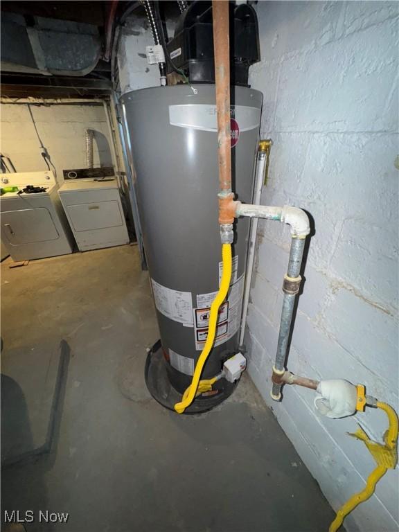 utility room with water heater and washer and dryer