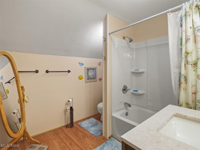 full bathroom with shower / bathtub combination with curtain, hardwood / wood-style floors, vanity, vaulted ceiling, and toilet