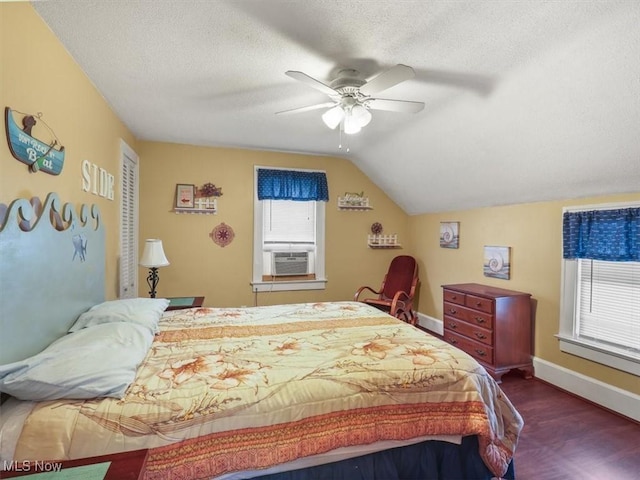 bedroom with lofted ceiling, dark wood-type flooring, ceiling fan, cooling unit, and a textured ceiling