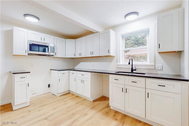 kitchen featuring white cabinetry, sink, and light hardwood / wood-style flooring