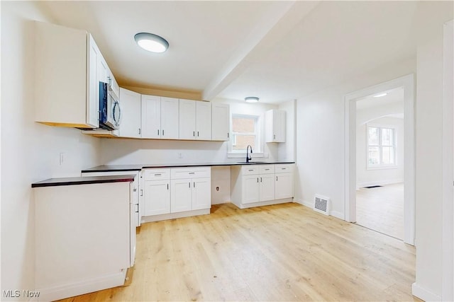 kitchen featuring sink, a wealth of natural light, light hardwood / wood-style flooring, and white cabinets