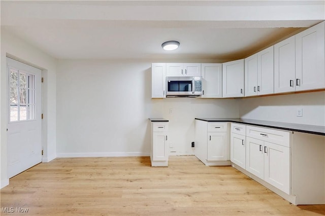 kitchen with light hardwood / wood-style floors and white cabinets