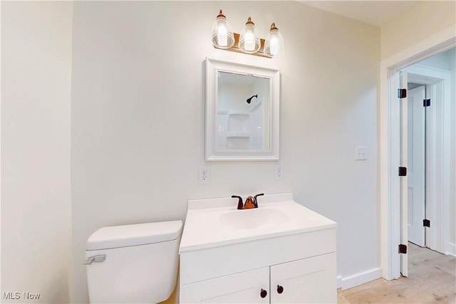 bathroom featuring vanity, hardwood / wood-style floors, and toilet