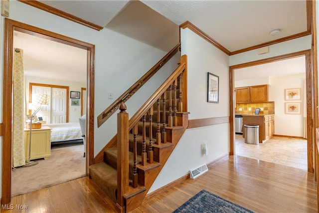 stairway featuring hardwood / wood-style flooring and ornamental molding