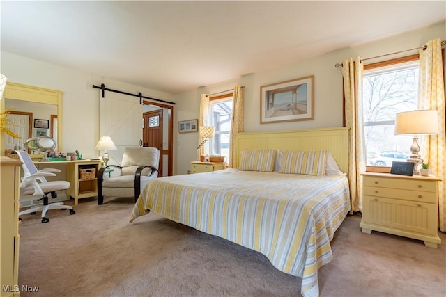 bedroom with light colored carpet and a barn door