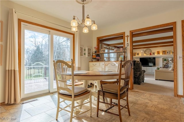 dining room with light tile patterned flooring and a notable chandelier