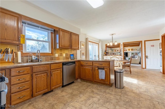 kitchen featuring sink, tasteful backsplash, dishwasher, kitchen peninsula, and pendant lighting