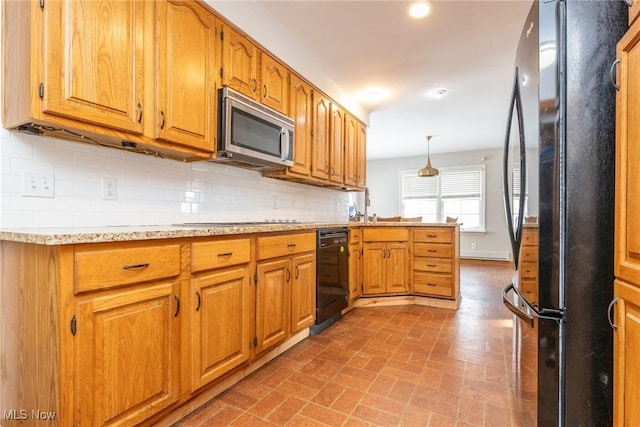 kitchen featuring decorative backsplash, hanging light fixtures, and black appliances