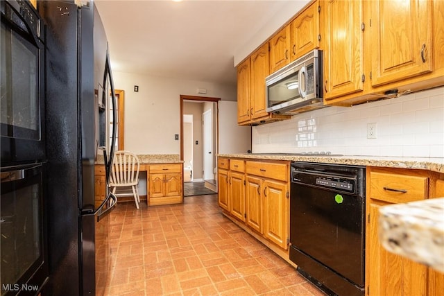 kitchen with decorative backsplash, built in desk, and black appliances