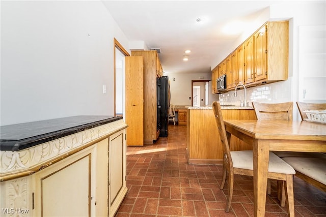 kitchen with backsplash and black fridge