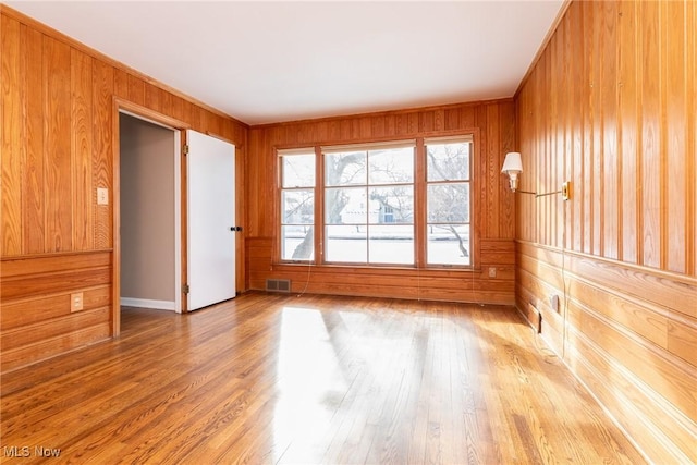 empty room with wood-type flooring and wooden walls