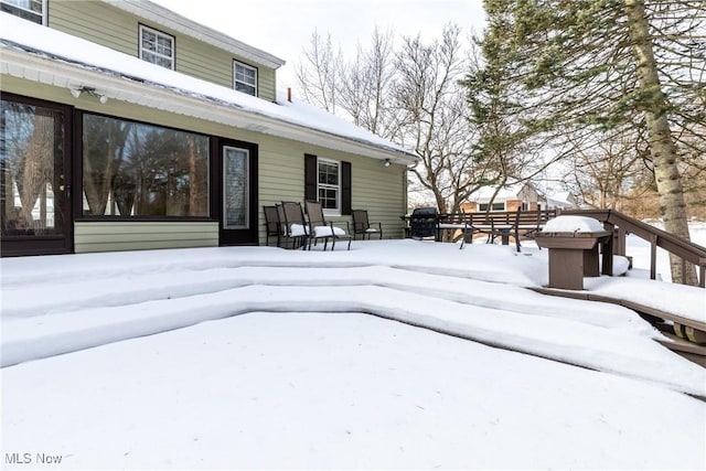 view of snow covered rear of property