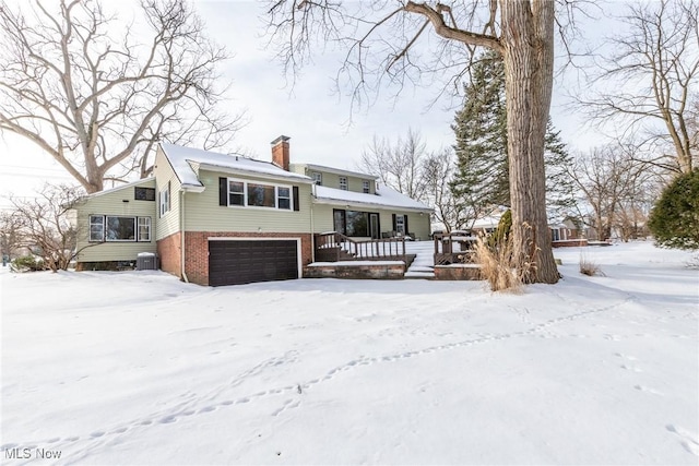 view of front of house with a garage and central air condition unit