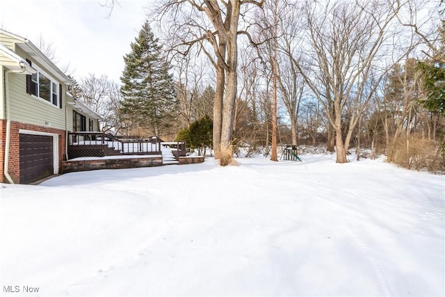 snowy yard with a garage