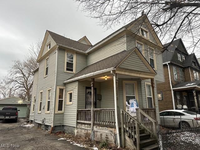 view of front facade featuring an outbuilding, a garage, and covered porch