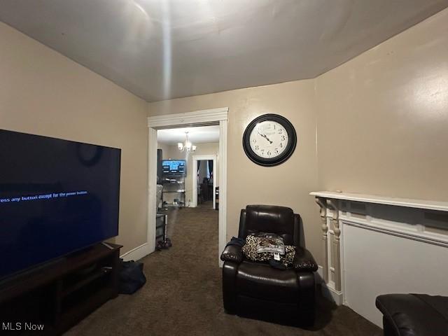 carpeted living room featuring a notable chandelier