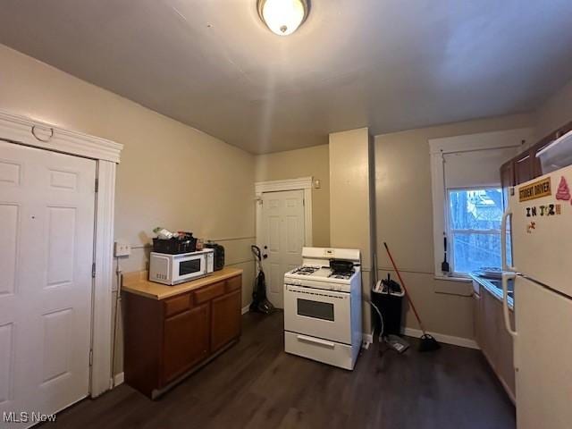 kitchen featuring dark wood-type flooring and white appliances