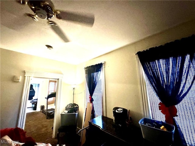 carpeted bedroom featuring ceiling fan and a textured ceiling