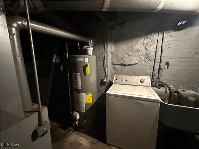 clothes washing area featuring washer / dryer, sink, and water heater