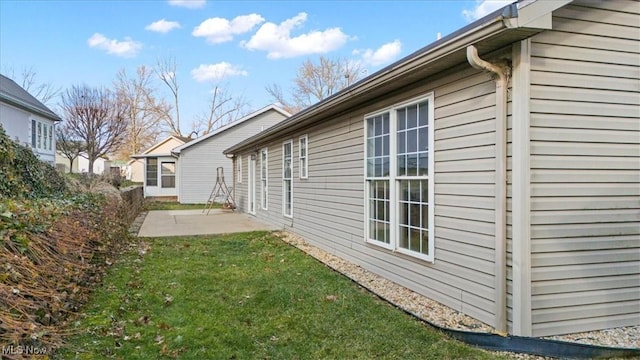 view of side of property with a yard and a patio area