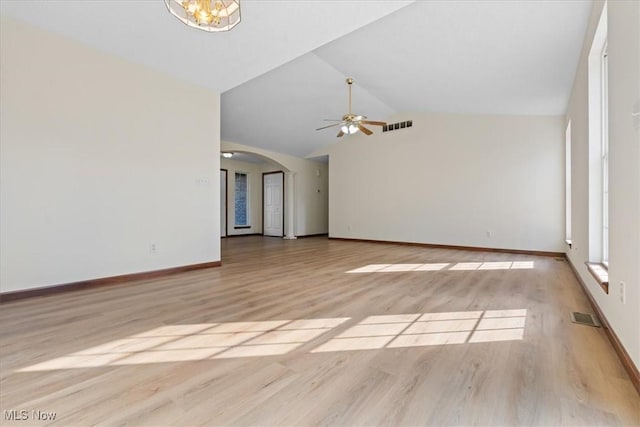 unfurnished living room featuring lofted ceiling, ceiling fan with notable chandelier, and light wood-type flooring