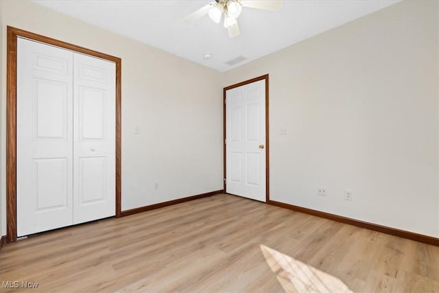 unfurnished bedroom featuring ceiling fan, light hardwood / wood-style floors, and a closet