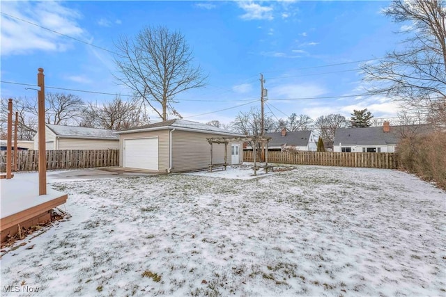 yard covered in snow with an outbuilding and a garage