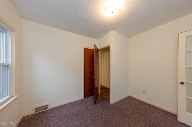 unfurnished bedroom with carpet flooring and a textured ceiling