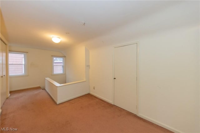 carpeted spare room with lofted ceiling