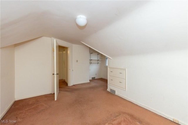 bonus room featuring lofted ceiling and light colored carpet