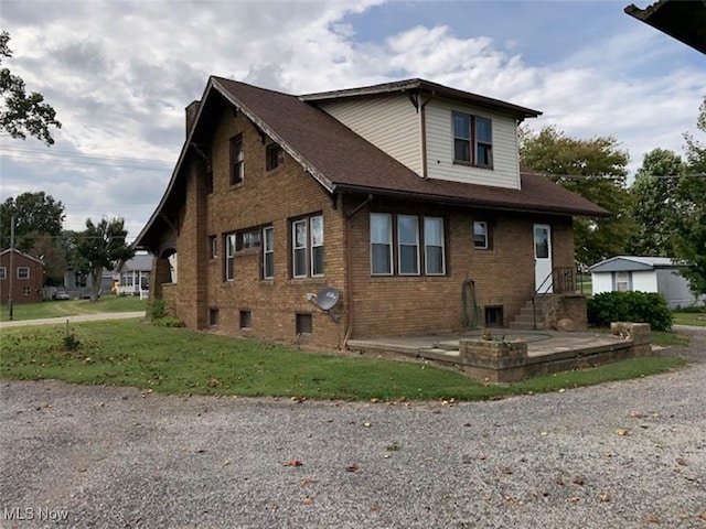 view of side of property with a yard and a patio