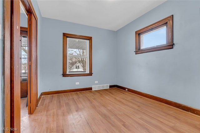 spare room featuring plenty of natural light and light hardwood / wood-style floors