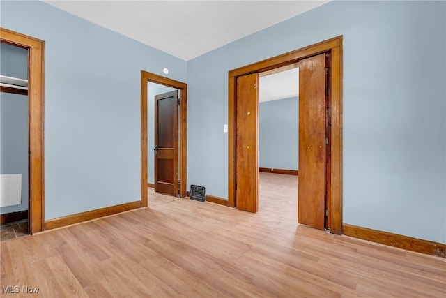 unfurnished bedroom featuring light hardwood / wood-style floors and a closet