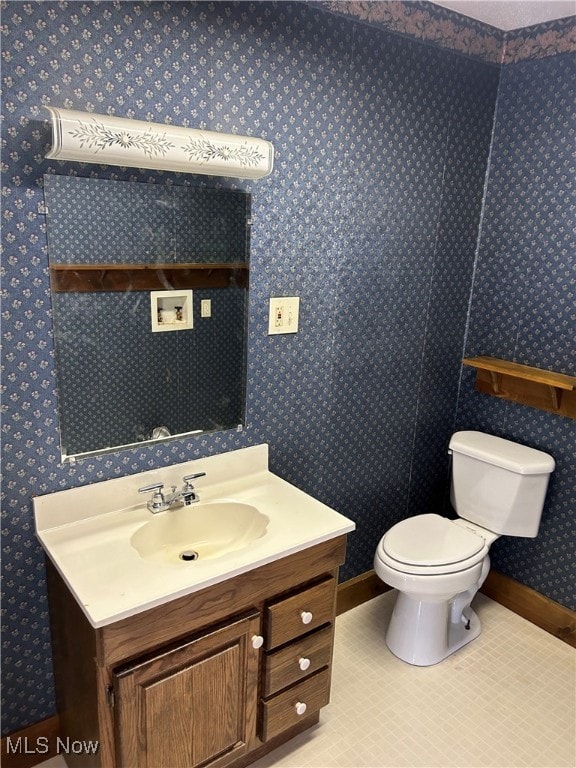 bathroom featuring tile patterned flooring, vanity, and toilet