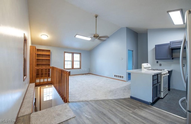 kitchen with dark hardwood / wood-style flooring, high vaulted ceiling, ceiling fan, and white gas range oven