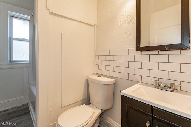 bathroom featuring vanity, tile walls, and toilet