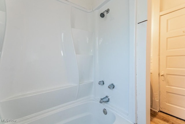 bathroom featuring hardwood / wood-style flooring and shower / bathtub combination